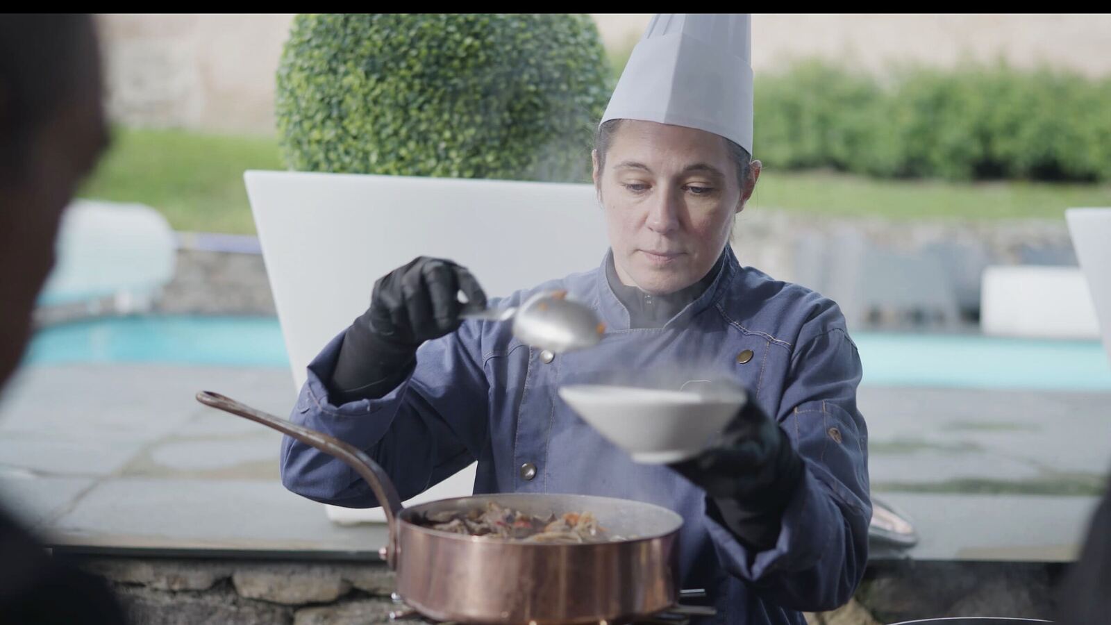 Une cheffe dresse une assiette lors d'une réception