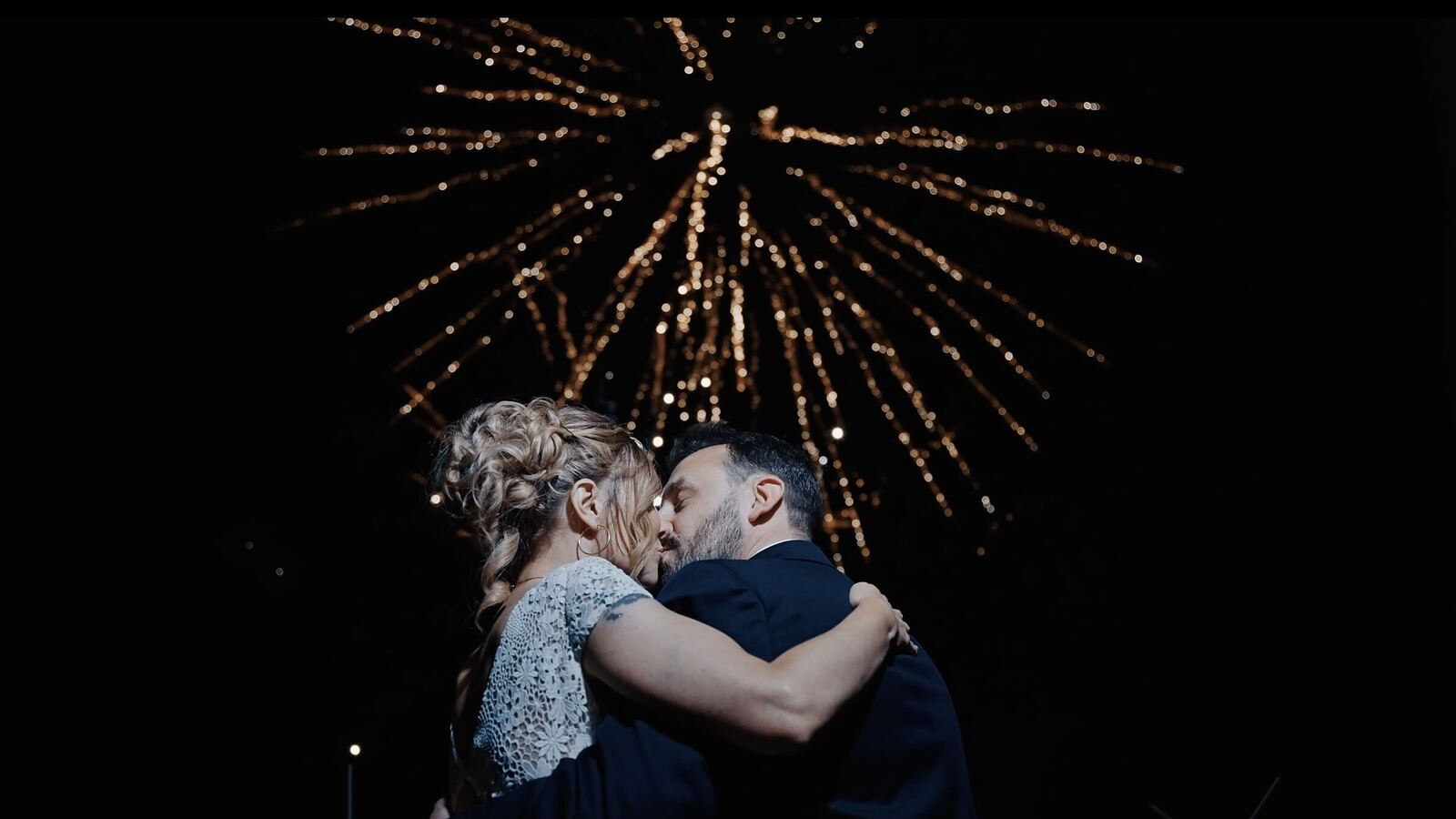 Baiser des mariés sous un feu d'artifice
