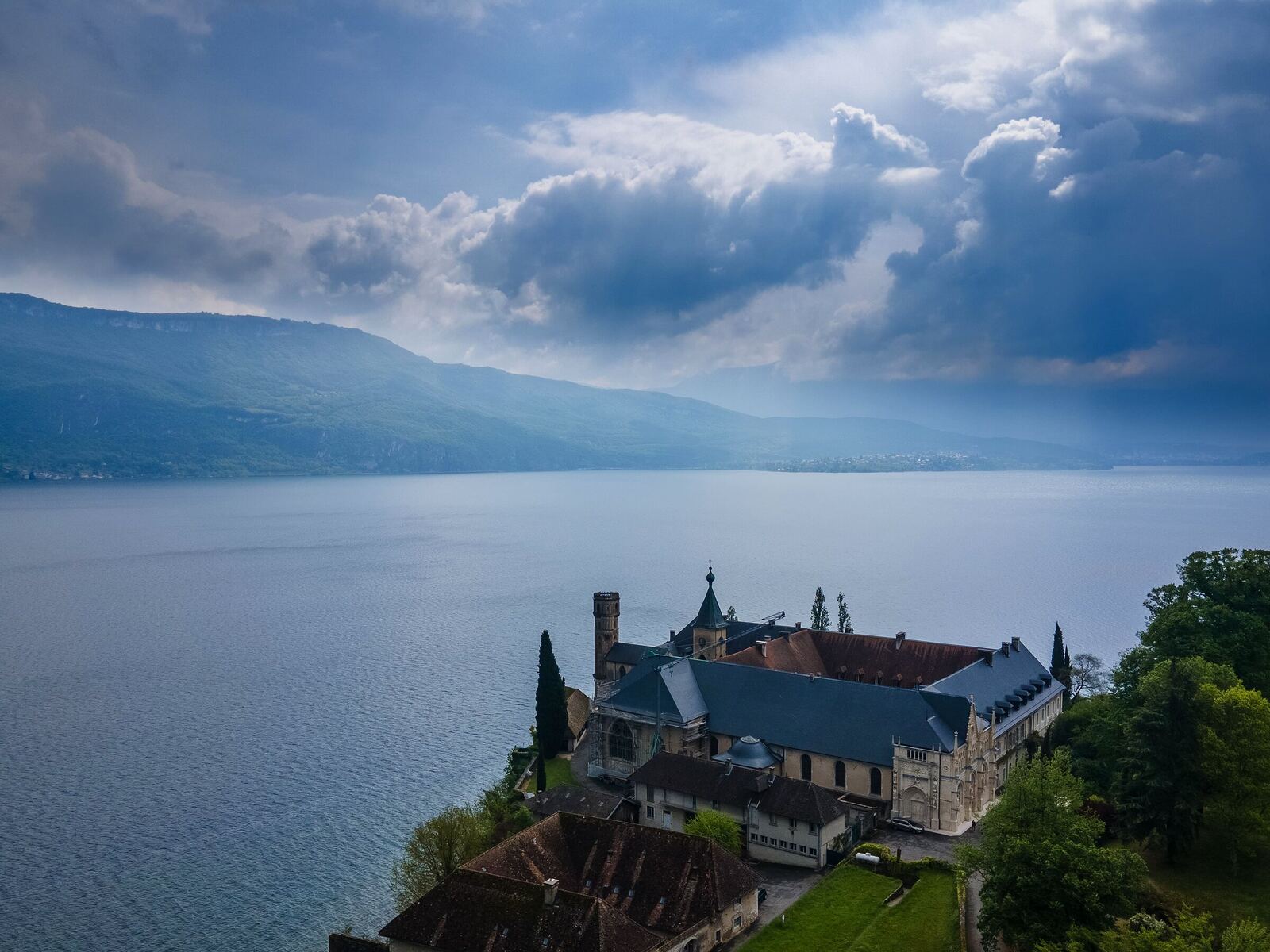 Abbaye au bord d'un lac sous un ciel d'orage